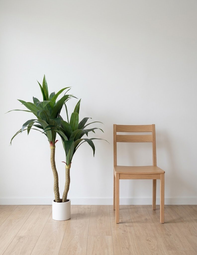 Dracena artificial grande de 135 cm con macetero blanco en un salón