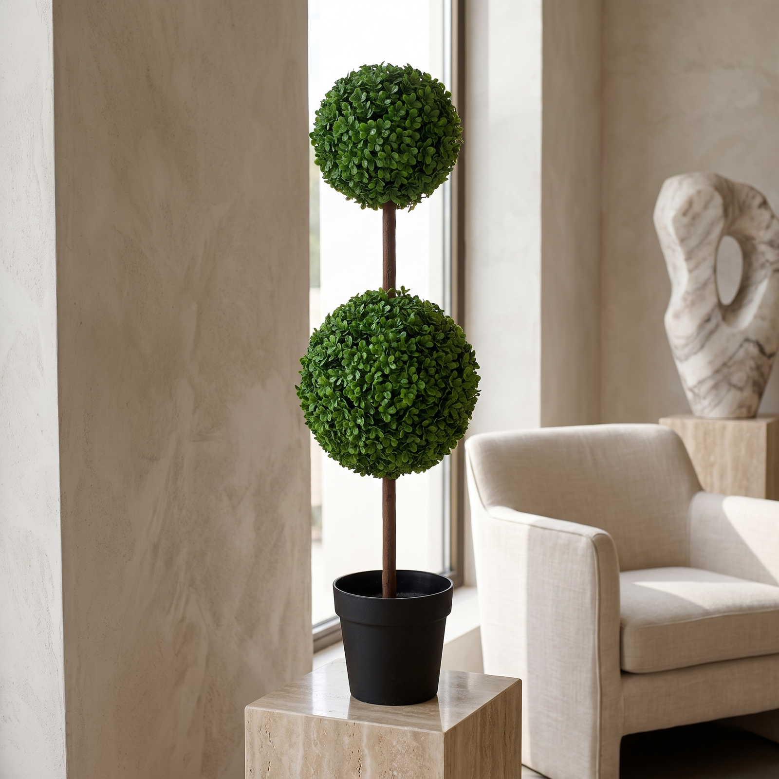 Topiario de boj artificial de 90 cm junto a una silla de madera