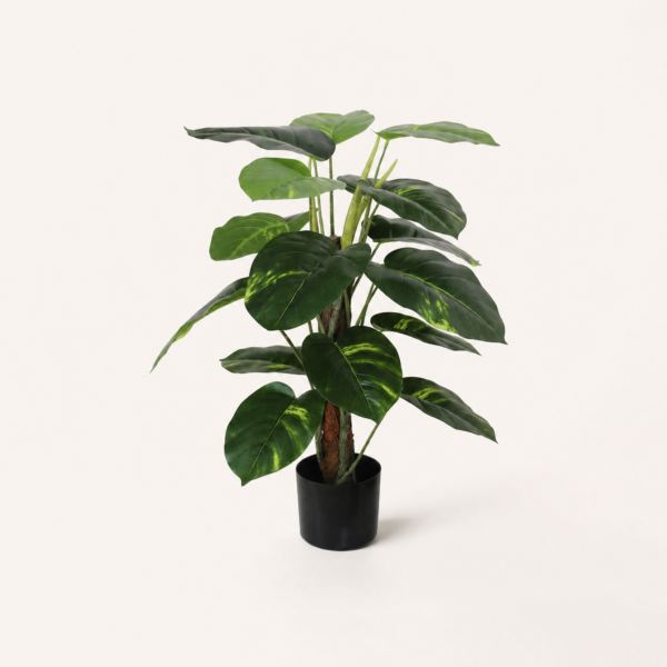 Planta artificial con maceta negra sobre fondo blanco